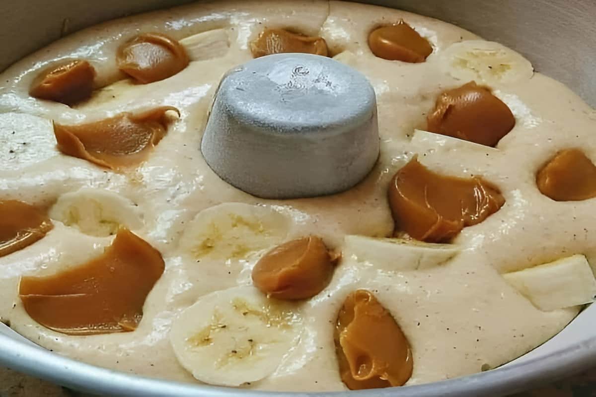 Bolo de banana que já sai do forno recheado com doce de leite e pedaços de banana