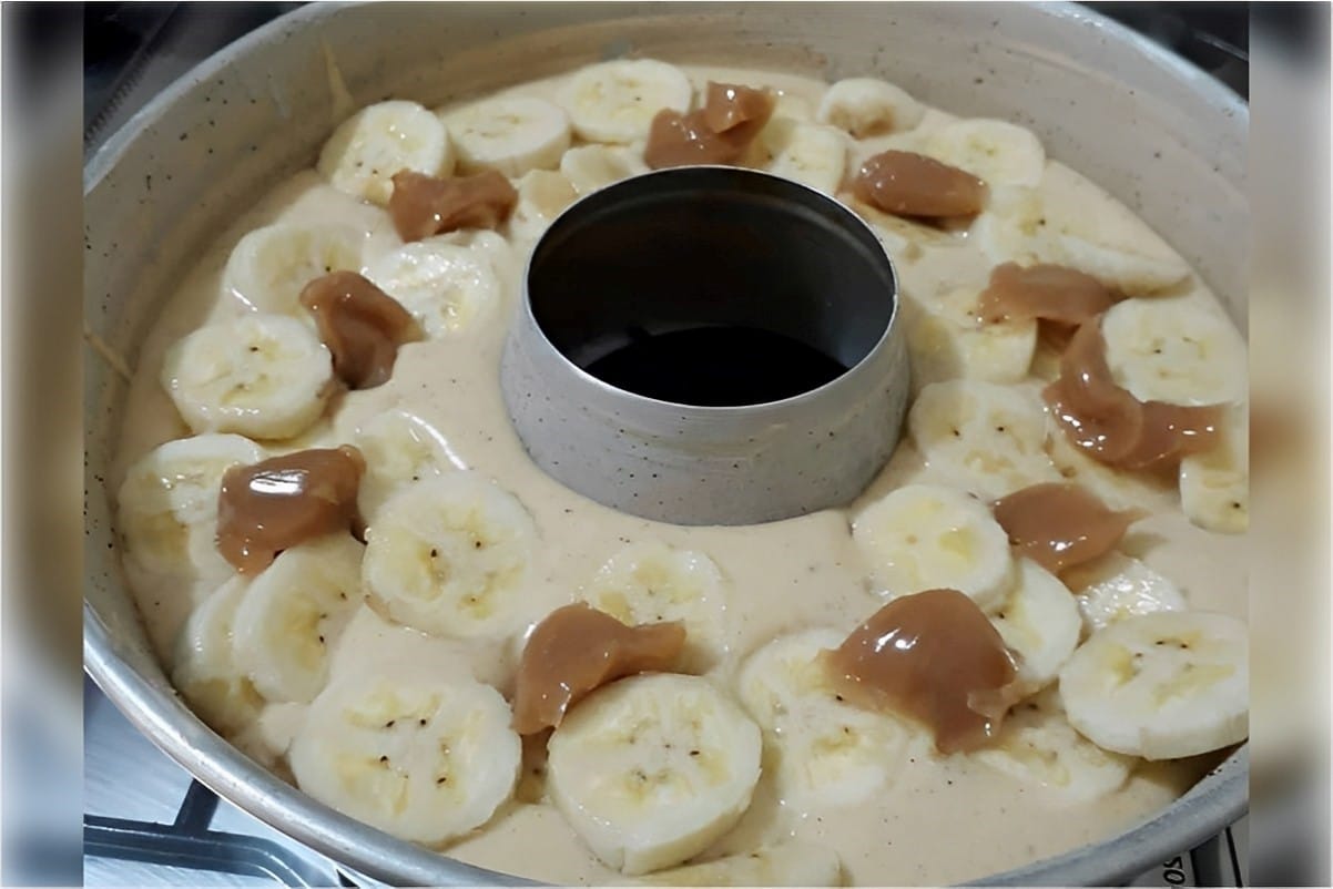 Bolo de banana que já sai do forno recheado com doce de leite e pedaços de banana