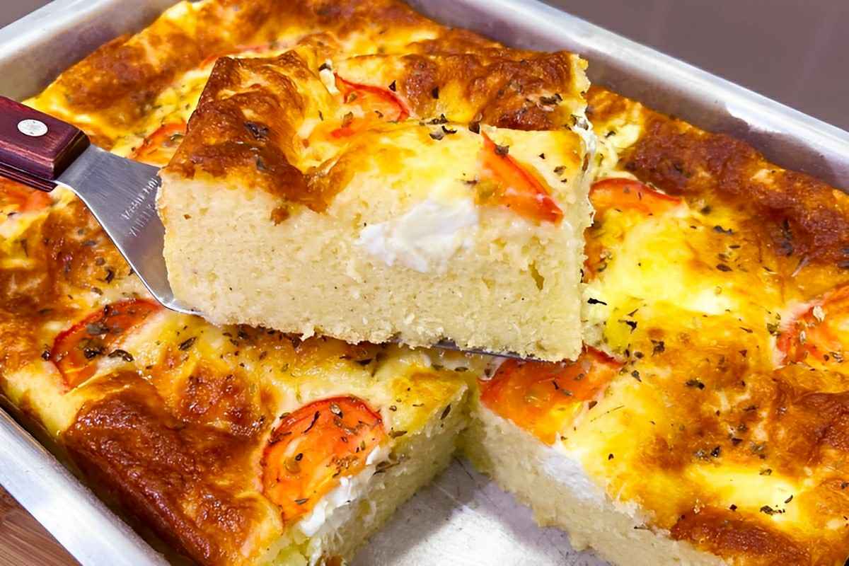 Torta salgada para o lanche com cobertura de queijo requeijão e tomates